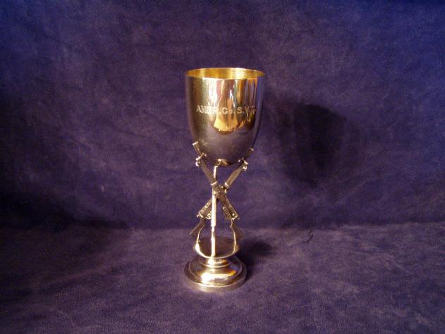 Shooting trophy w/ bowl atop three WWI crossed bolt action rifles